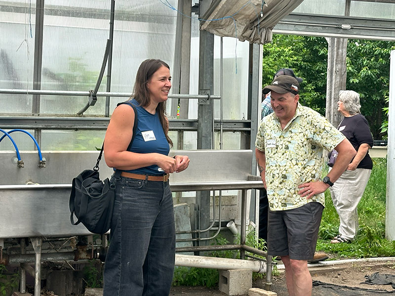 two people talking in a greenhouse