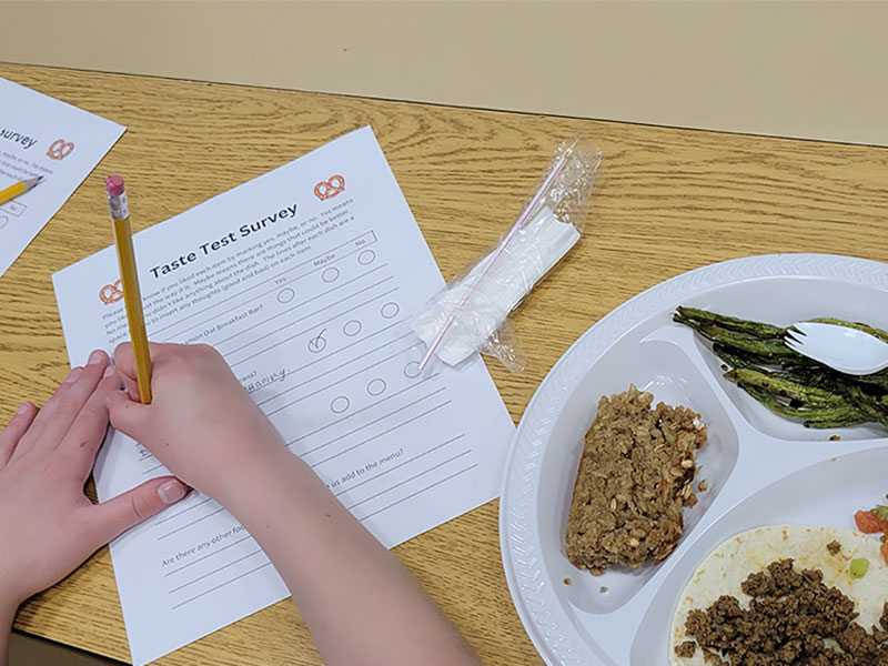 Childs hands filling out a taste test