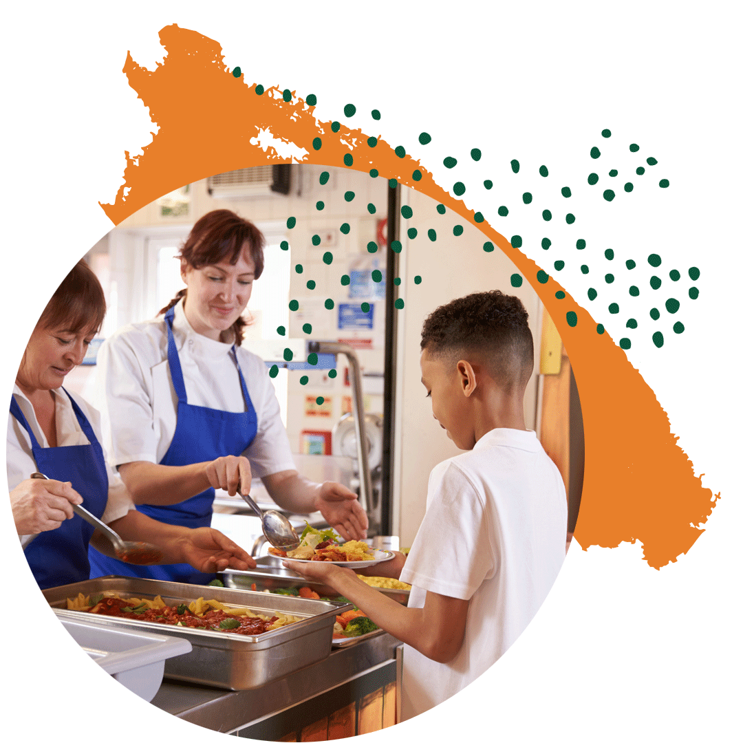 Un niño al que le están sirviendo el almuerzo en un comedor escolar.