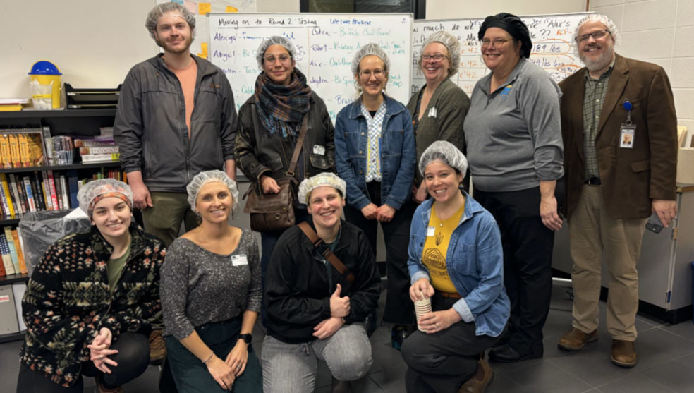 foto de grupo del equipo Food Futures durante su visita a la Escuela de Educación Técnica Profesional de Muskegon, donde el equipo aprendió a trabajar con los estudiantes para procesar papas y otros alimentos locales e integrarlos en las comidas escolares.