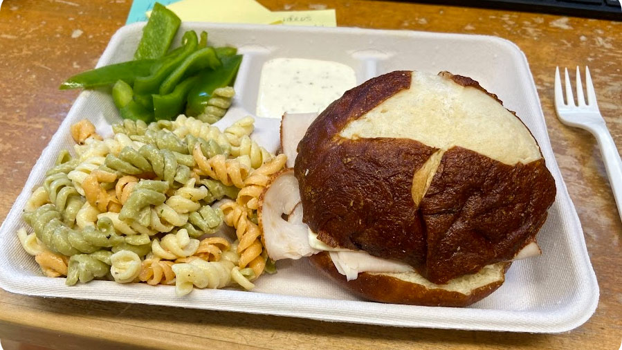 lunch tray with bread, greens and pasta